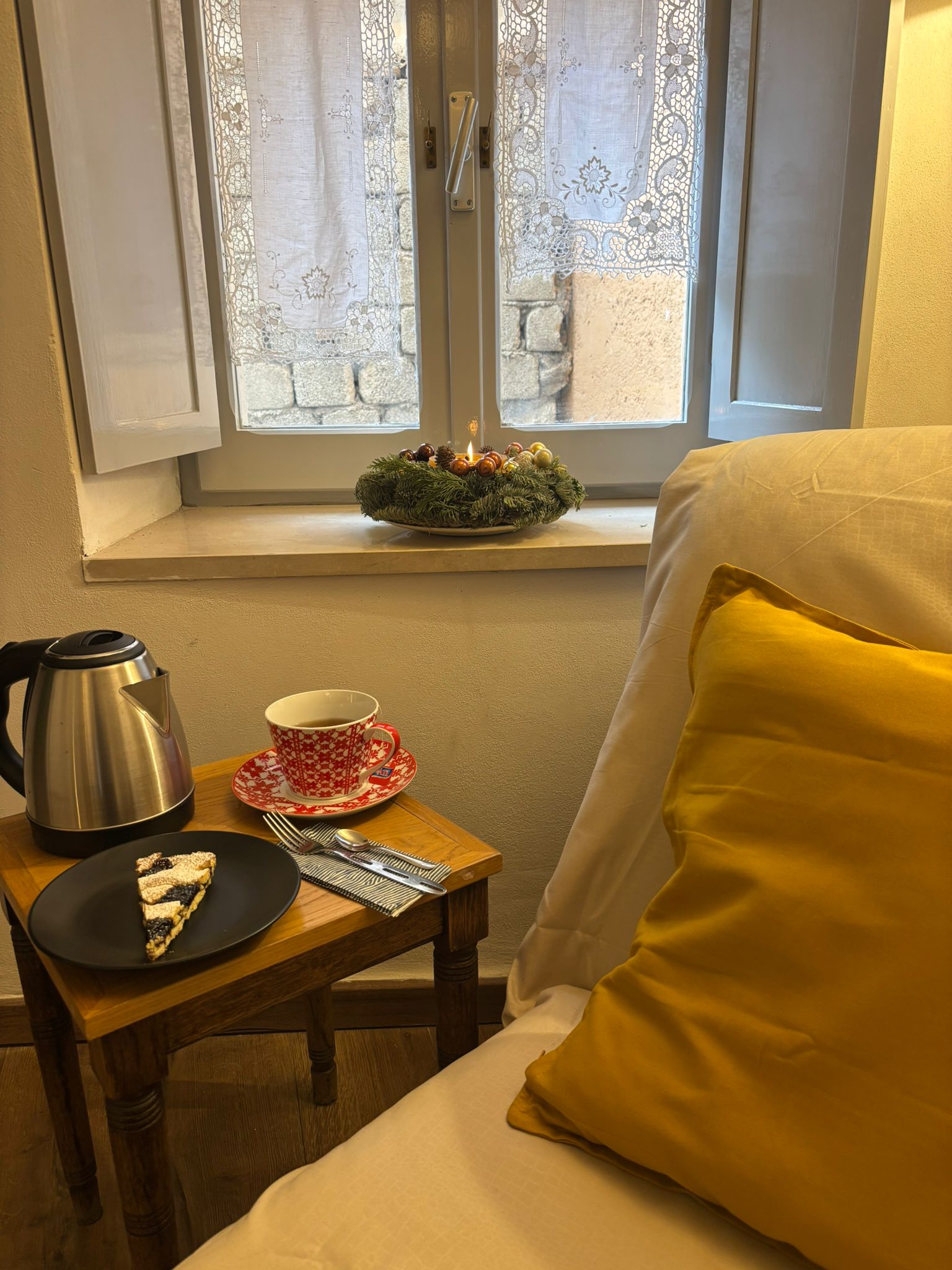 Angolo letto con cuscino giallo vicino alla finestra